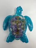 Sea Turtle 5 inch Aqua- Blue floral, Green jeweled cross. Created from epoxy. Turtle has faux diamond eyes. Item 311